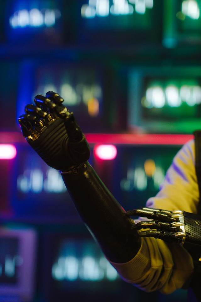 A robotic hand lit in neon