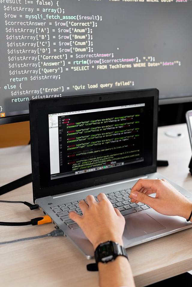 Code on a monitor beside a keyboard