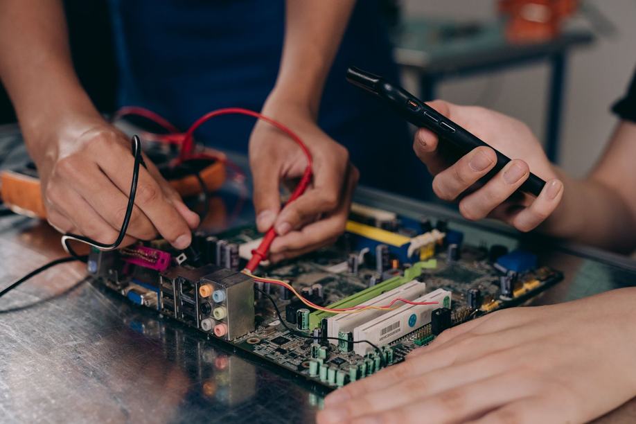 Hands wiring a microcontroller on a breadboard
